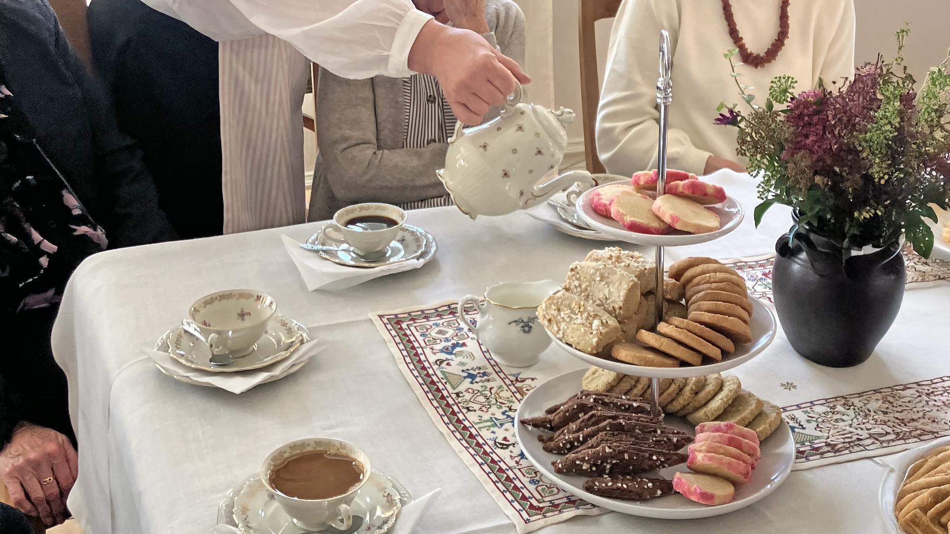 Bord dukat med kakfat och kaffekoppar.