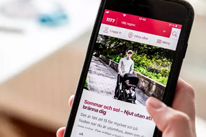 Hand som håller mobil där sidan 1177 är synlig.